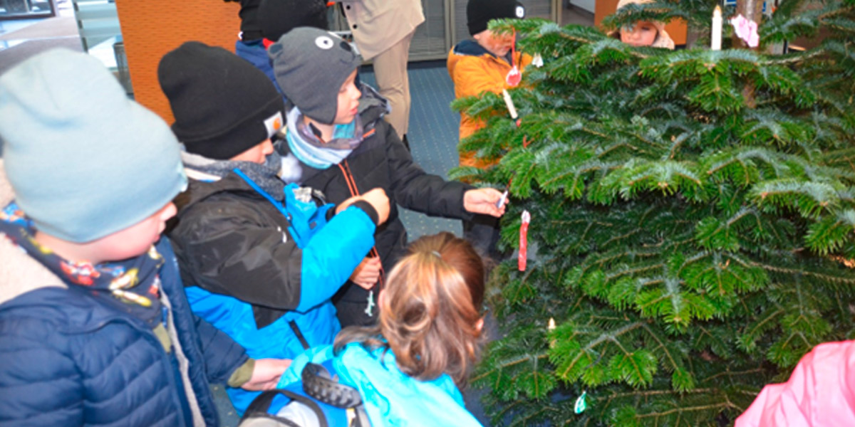 Vorschulkinder schmücken Tannenbaum